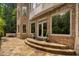 Rear exterior of brick home showcasing stone patio, walkway, and lush greenery, creating an inviting outdoor space at 3601 Nightfall Ct, Raleigh, NC 27607