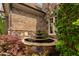 A beautiful stone fountain is nestled between brick and stone walls near the green landscaping at 3601 Nightfall Ct, Raleigh, NC 27607