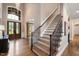 Grand foyer boasts hardwood floors, staircase with iron spindles, chandelier, and large windows at 3601 Nightfall Ct, Raleigh, NC 27607