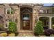 Stunning front entrance with stone archway, double wood doors, sidelights, and manicured landscaping at 3601 Nightfall Ct, Raleigh, NC 27607