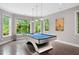 Bright game room featuring a uniquely designed pool table and backyard views at 3601 Nightfall Ct, Raleigh, NC 27607