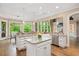 Open kitchen with center island, granite countertops, a stainless dishwasher, and large bright windows at 3601 Nightfall Ct, Raleigh, NC 27607