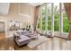 Bright living room with floor-to-ceiling windows, hardwood floors, and neutral decor open to kitchen at 3601 Nightfall Ct, Raleigh, NC 27607
