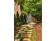 Stone path with greenery leading to a fence, nestled in a lush, wooded area at 3601 Nightfall Ct, Raleigh, NC 27607