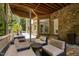 Covered patio area featuring comfortable seating, a swing, and stone flooring, perfect for outdoor relaxation and entertaining at 3601 Nightfall Ct, Raleigh, NC 27607
