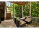 Covered patio with stone flooring, comfortable seating, and steps leading to a green lawn, seamlessly blending indoor and outdoor living at 3601 Nightfall Ct, Raleigh, NC 27607