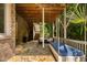 Covered patio showcases a swing and outdoor seating on a stone surface, perfect for enjoying the serene surroundings at 3601 Nightfall Ct, Raleigh, NC 27607