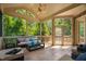 Relaxing screened porch with brick accent wall, ceiling fan and sliding glass doors to a wooden outdoor grill deck at 3601 Nightfall Ct, Raleigh, NC 27607