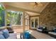 Relaxing screened porch with brick accent wall, ceiling fan and sliding glass doors to a wooden outdoor grill deck at 3601 Nightfall Ct, Raleigh, NC 27607