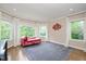 Bright sitting room featuring large windows, hardwood floors, and stylish decor at 3601 Nightfall Ct, Raleigh, NC 27607