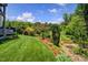 Well-maintained backyard with green lawn, flowers and a hot tub and landscaped garden at 372 Farnleigh Dr, Chapel Hill, NC 27517