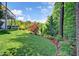 Landscaped backyard with lush green grass, colorful flowerbeds, and mature trees at 372 Farnleigh Dr, Chapel Hill, NC 27517