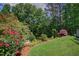Beautiful backyard featuring lush landscaping, mature trees, and vibrant flower beds at 372 Farnleigh Dr, Chapel Hill, NC 27517
