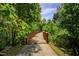 Picturesque wooden walking bridge surrounded by lush greenery, ideal for a peaceful stroll and nature immersion at 372 Farnleigh Dr, Chapel Hill, NC 27517
