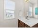 Bright bathroom with a white countertop, wood cabinets, and a window providing natural light at 3913 Massey Pointe Ct, Raleigh, NC 27616
