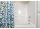 Clean white shower and tub featuring a blue floral shower curtain and chrome fixtures at 3913 Massey Pointe Ct, Raleigh, NC 27616