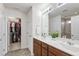 Bathroom with double sinks, wood cabinets, and a view to the walk in closet at 3913 Massey Pointe Ct, Raleigh, NC 27616