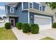Two-story home featuring blue siding, a two-car garage, and manicured landscaping with lush green bushes at 3913 Massey Pointe Ct, Raleigh, NC 27616