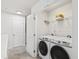 Bright laundry room featuring modern Samsung washer and dryer and wire shelving at 3913 Massey Pointe Ct, Raleigh, NC 27616