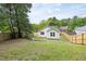 Charming backyard featuring a new wooden fence, green grass, and a view of the white siding on the home at 407 Sparella St, Durham, NC 27703