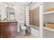 Bathroom features a tub/shower combo with tile surround, open shelving and a granite-topped vanity at 407 Sparella St, Durham, NC 27703