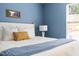 A nicely decorated bedroom features blue walls, neutral bedding with a blue throw, and wood floors at 407 Sparella St, Durham, NC 27703