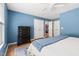 Bedroom featuring blue walls, a neutral bed with blue accents, wood floors, and closet doors at 407 Sparella St, Durham, NC 27703
