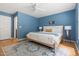Bedroom with blue walls, a ceiling fan, neutral bed with blue accents, and wood floors at 407 Sparella St, Durham, NC 27703