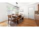Dining area featuring a wooden table, bench seating, and hardwood floors, illuminated by modern light at 407 Sparella St, Durham, NC 27703