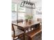 Dining area with wooden table, chairs, bench and modern chandelier over stylish rug at 407 Sparella St, Durham, NC 27703
