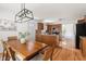 Open kitchen and dining area with wooden cabinets, island, hardwood floors, and modern lighting at 407 Sparella St, Durham, NC 27703