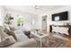 Inviting living room featuring a large sofa, hardwood floors, natural light, and a neutral color scheme at 407 Sparella St, Durham, NC 27703