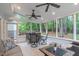 Relax in this sunroom featuring wooded views, tile floors, and several ceiling fans to stay cool at 408 Dairy Farm Dr, Hillsborough, NC 27278