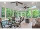 Bright and airy sunroom with a glass dining table and views of the wooded backyard at 408 Dairy Farm Dr, Hillsborough, NC 27278
