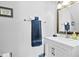 Well-lit bathroom featuring a white vanity, framed mirror, and a neatly arranged dark blue towel at 4104 Panther Creek Pkwy, Durham, NC 27704