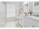 Bright bathroom with double vanity, white cabinets, marble countertop, and neutral tile flooring at 4104 Panther Creek Pkwy, Durham, NC 27704