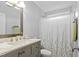 Neutral bathroom features a vanity with a framed mirror and a shower with a decorative curtain at 4104 Panther Creek Pkwy, Durham, NC 27704