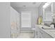 Bright bathroom featuring double vanity, white cabinets, marble countertops, and tile flooring at 4104 Panther Creek Pkwy, Durham, NC 27704