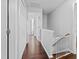 Hallway featuring hardwood floors, white trim, and a baby gate at the bottom of the staircase at 4104 Panther Creek Pkwy, Durham, NC 27704