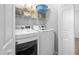 Bright laundry room featuring modern white appliances, wire shelving, and ample storage space at 4104 Panther Creek Pkwy, Durham, NC 27704
