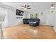 Bright living room featuring hardwood floors, a ceiling fan, and a comfortable black leather sectional sofa at 4104 Panther Creek Pkwy, Durham, NC 27704