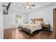 Comfortable main bedroom with a wooden bed frame, hardwood floors, and natural light from the window at 4104 Panther Creek Pkwy, Durham, NC 27704