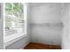 Bright walk-in closet featuring hardwood floors, a window with blinds, and wire shelving at 4104 Panther Creek Pkwy, Durham, NC 27704