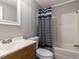 Bathroom with a shower/tub combo, white tile, and a gray and blue shower curtain at 4125 Brushy Ridge Dr, Holly Springs, NC 27540