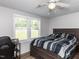 Cozy bedroom featuring wood-look floors, natural light, and a ceiling fan at 4125 Brushy Ridge Dr, Holly Springs, NC 27540