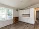 Bright living room featuring wood-look floors, white cabinets, and natural light from large windows at 4125 Brushy Ridge Dr, Holly Springs, NC 27540