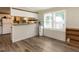 Open-concept living space with breakfast bar, wood-look flooring, and bright natural light at 4125 Brushy Ridge Dr, Holly Springs, NC 27540