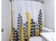Bathroom with a shower featuring a curtain with yellow and grey leaf pattern, toilet, and simple sink at 4206 Camden Woods Ct, Raleigh, NC 27612
