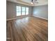 Large bedroom with hardwood flooring, tray ceiling, ceiling fan, and three windows at 4206 Camden Woods Ct, Raleigh, NC 27612
