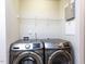 Convenient laundry room equipped with a modern washer and dryer set and functional shelving at 4206 Camden Woods Ct, Raleigh, NC 27612